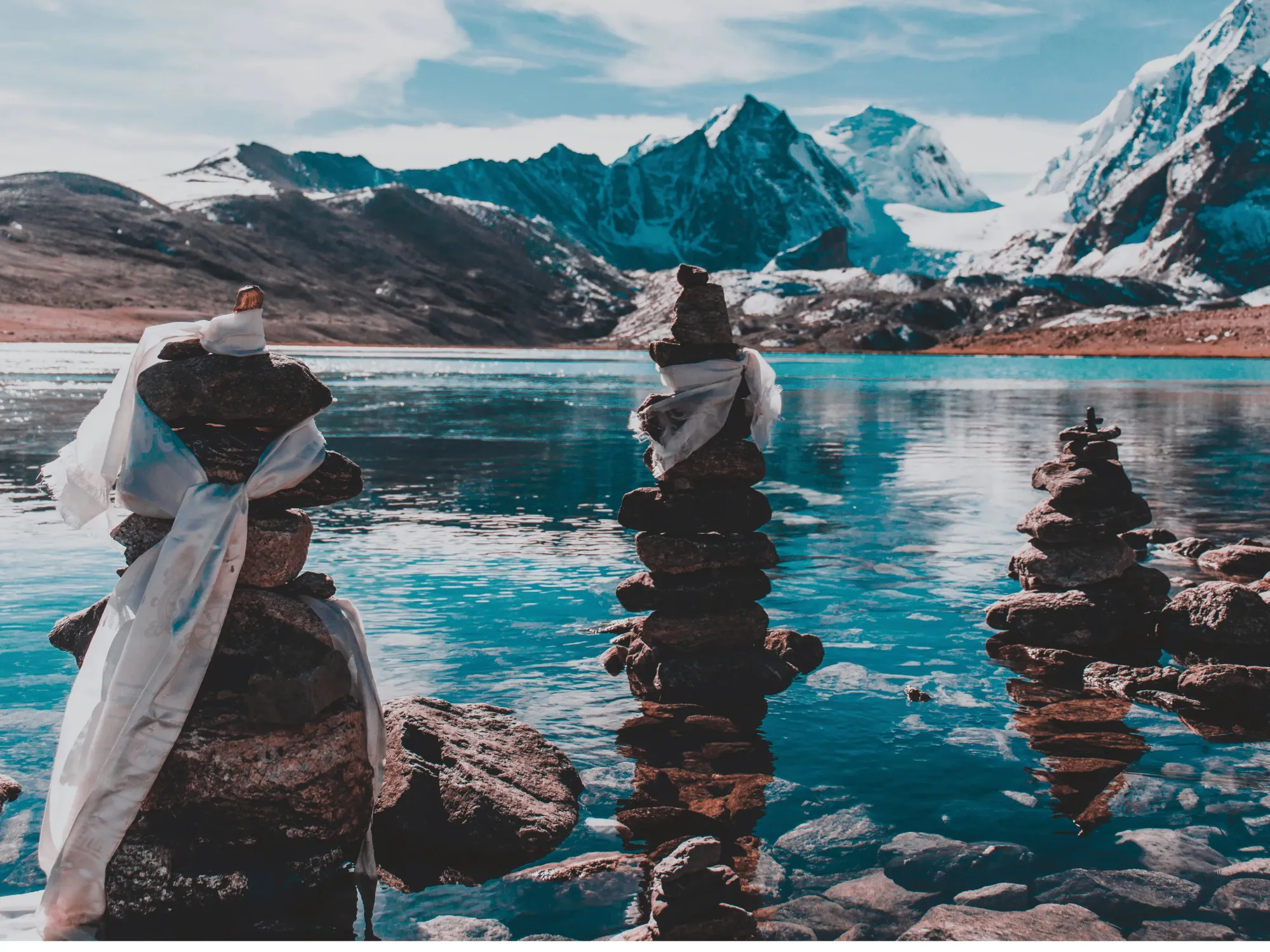 Prayer cairns draped in khada scarves at Gurudongmar Lake